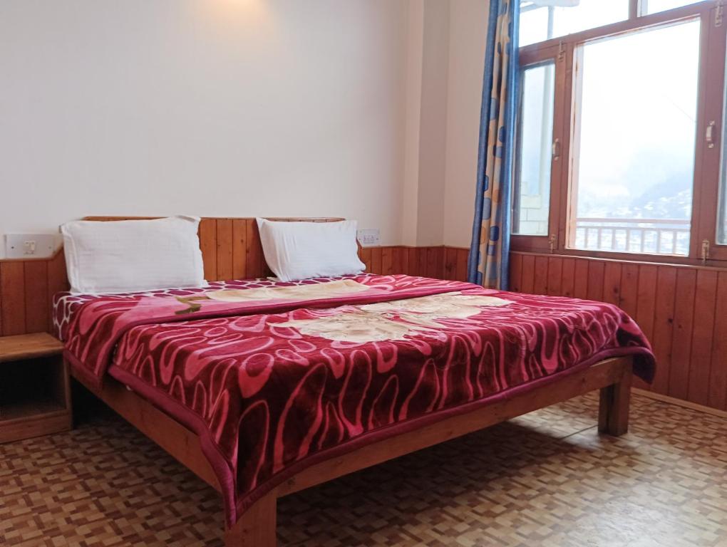 馬拉里的住宿－ROOP MOUNTAIN HOMESTAY，一张床上的床上,上面有红毯