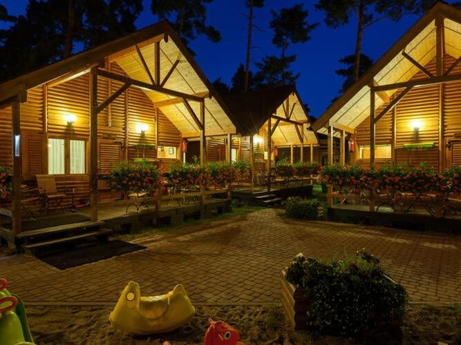 a large wooden building with a toy in front of it at Holiday houses near the seaside beach, Pobierowo in Pobierowo