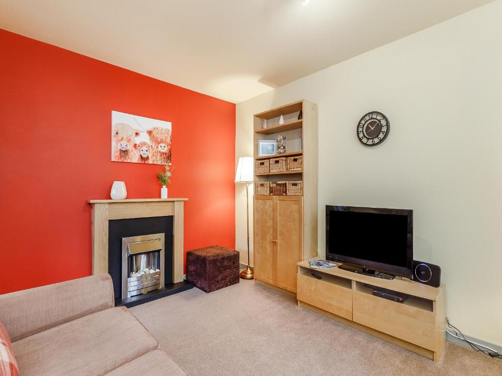 a living room with a tv and a fireplace at Church Court Cottage - Uk39009 in Halkirk