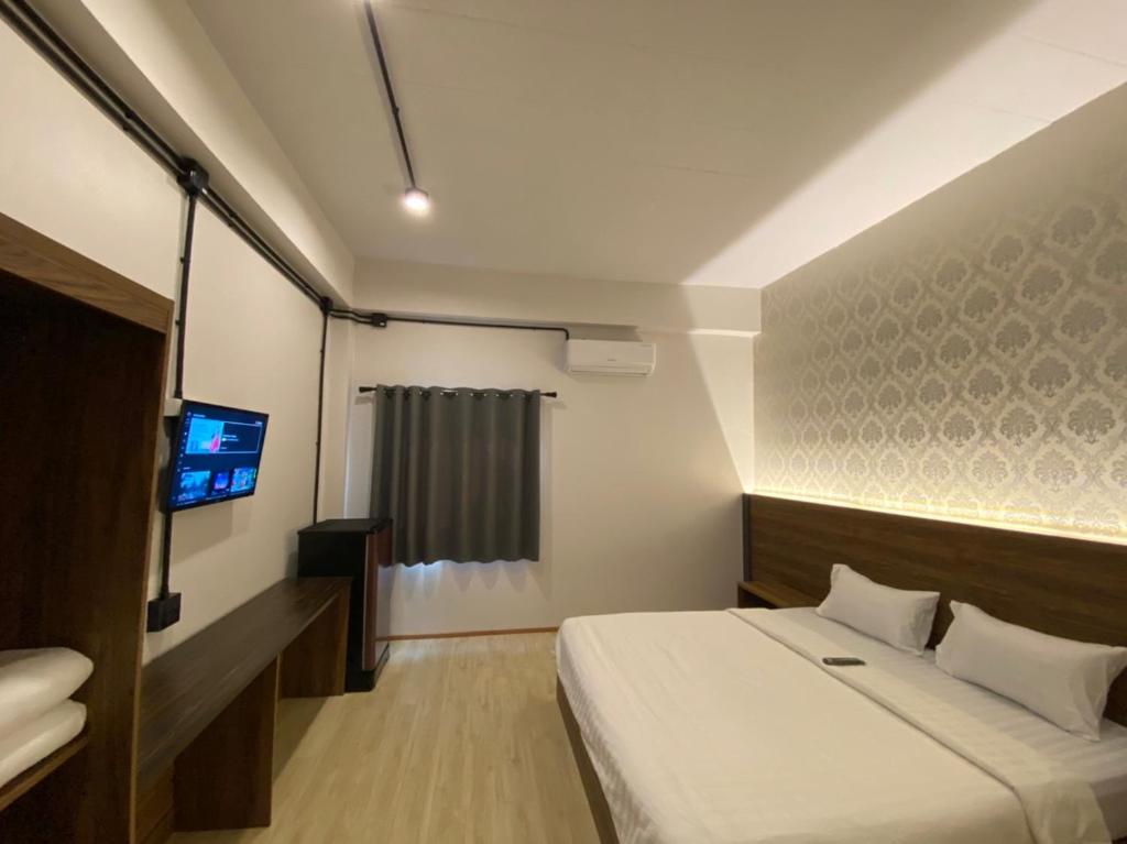 Habitación de hotel con cama y TV en Red Heritage Hotel, en Ban Mon