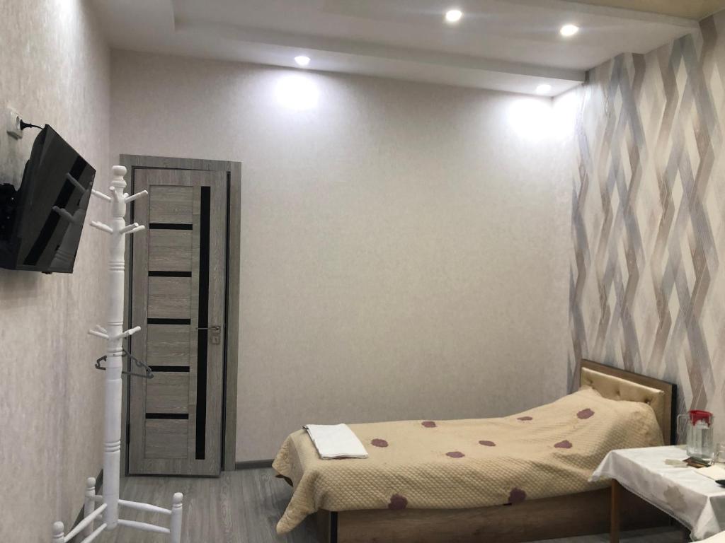 a bedroom with a bed and a television in a room at Дом Отель Бадамзар in Tashkent