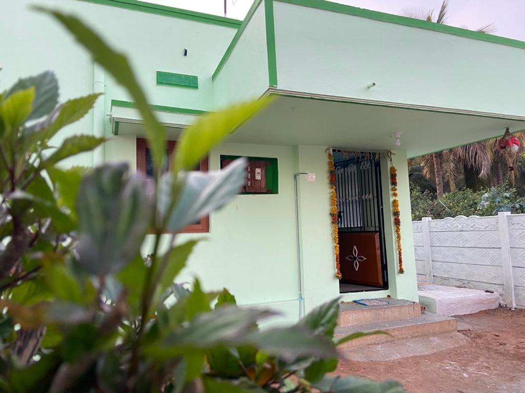 une maison blanche avec une porte et une clôture dans l'établissement Castle50 - Green Villa homestay, à Coimbatore