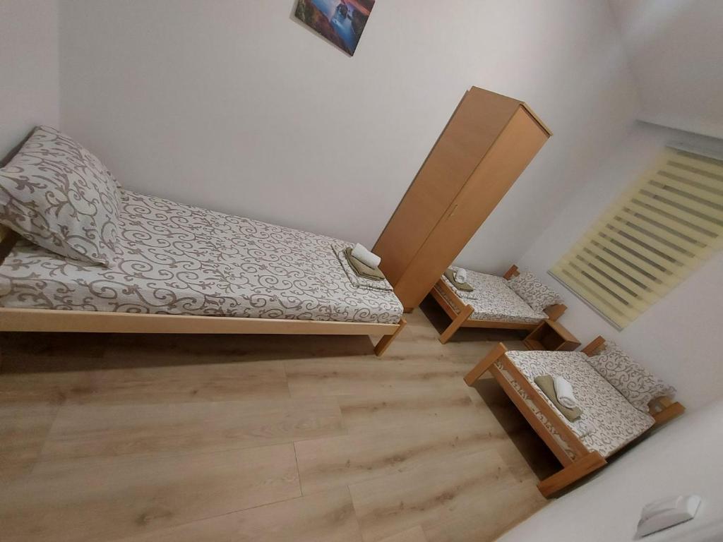 a bedroom with a bed and a wooden floor at Platan 2 in Bela Crkva