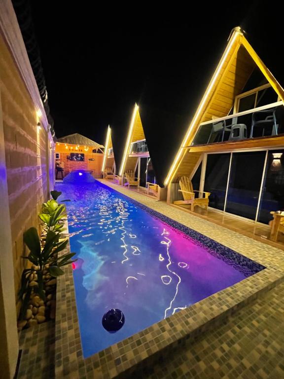 - une piscine au milieu d'une maison la nuit dans l'établissement Villa completa confotable para 9 personas, à Pedernales