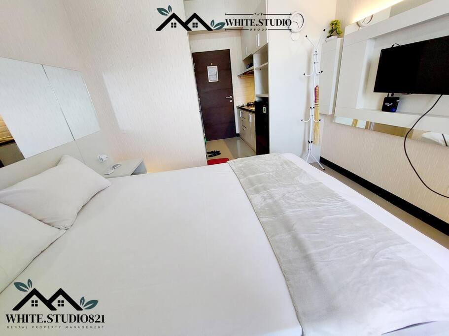 a hospital room with a white bed and a tv at White Studio Group Surabaya - WS 821 at Amega Crown Residence in Tambakoso