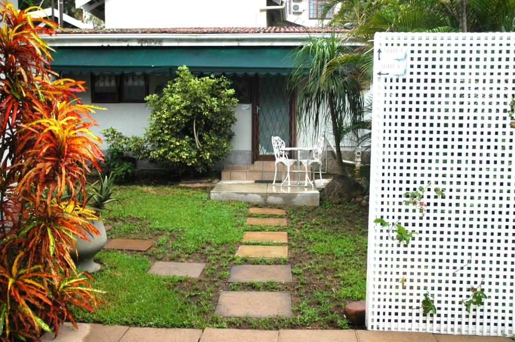 a garden with a chair and a table in front of a house at Northlands Manor in Durban