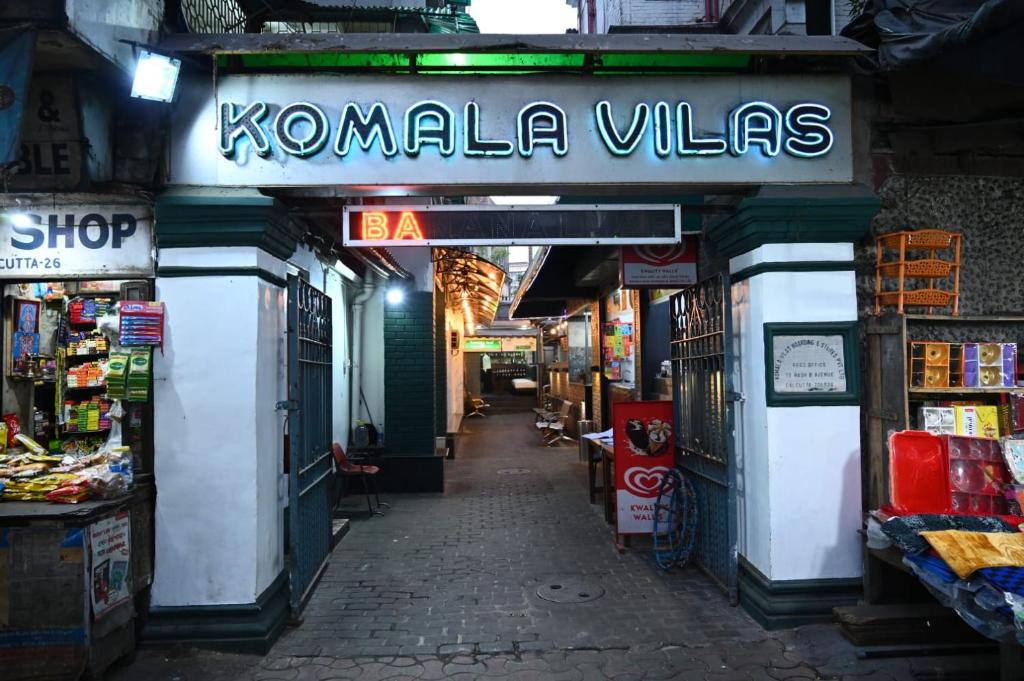 een winkel met een bord dat komale dorpen leest bij Hotel Komala Vilas in Calcutta