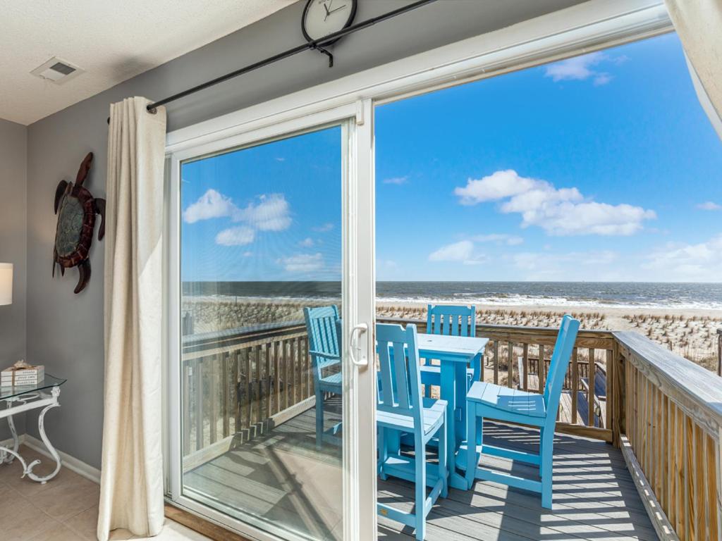 a balcony with blue chairs and a view of the ocean at Tybee Lights 110C in Tybee Island