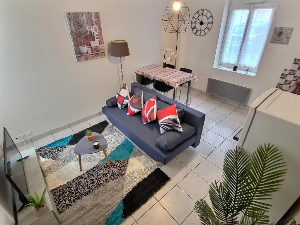 Superbe Type 2 - Cosy et Chaleureux في بوغينايس: غرفة معيشة مع أريكة زرقاء وطاولة