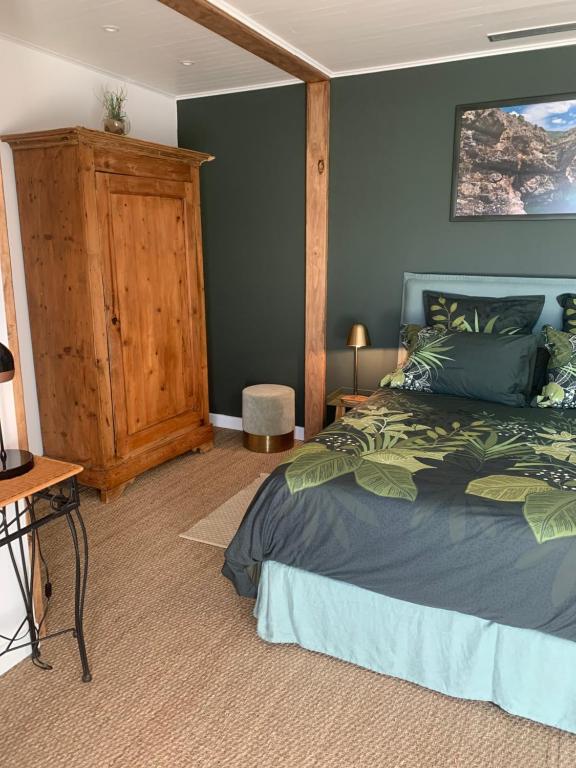 a bedroom with a bed and a wooden cabinet at Chambre d'hôtes A Vadina Porticcio in Porticcio
