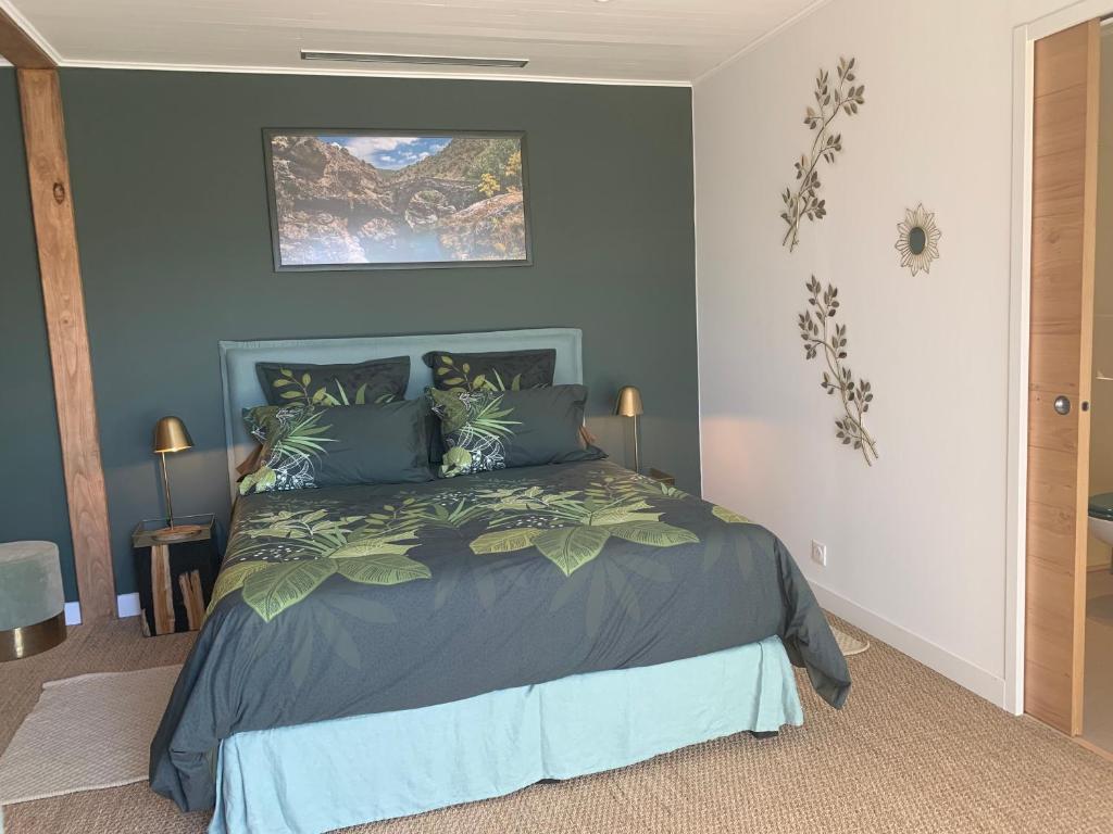 a bedroom with a bed with a gray comforter at Chambre d'hôtes A Vadina Porticcio in Porticcio