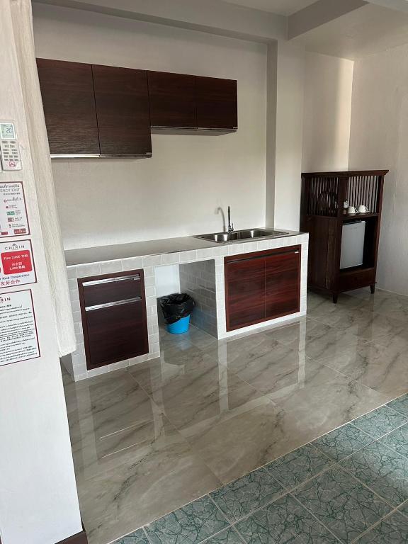 A shared-looking kitchenette with a sink, cabinets and storage cabinet.