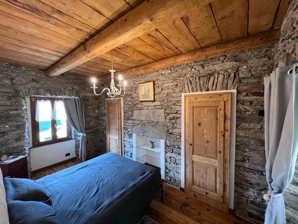 a bedroom with a bed and a stone wall at Appartamento completamente ristrutturato in Montecrestese