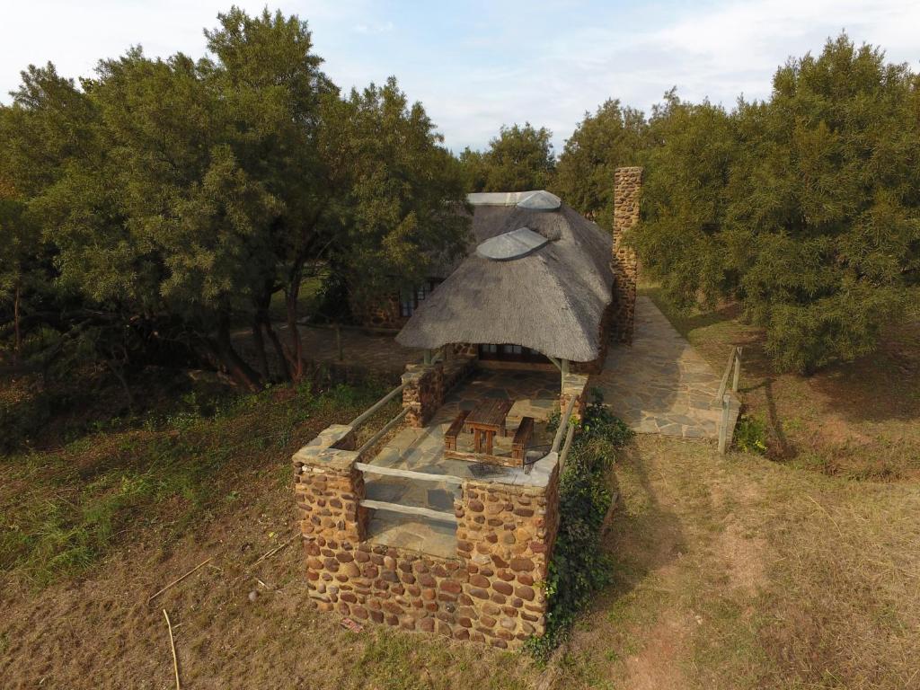 a small brick house with a roof on a field at Hollybrooke Adventure Farm in Skeerpoort