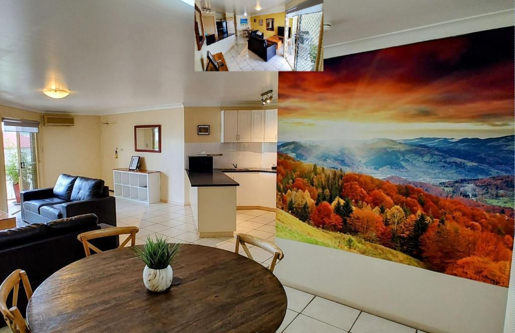 una sala de estar con una mesa y una pintura en la pared en Grand Central Apartment, en Toowoomba