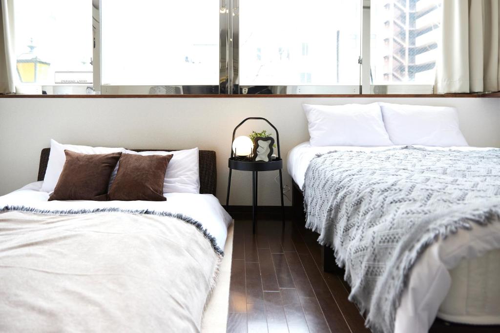 two beds sitting next to each other in a bedroom at ZEROSHARE CHIKKO in Osaka