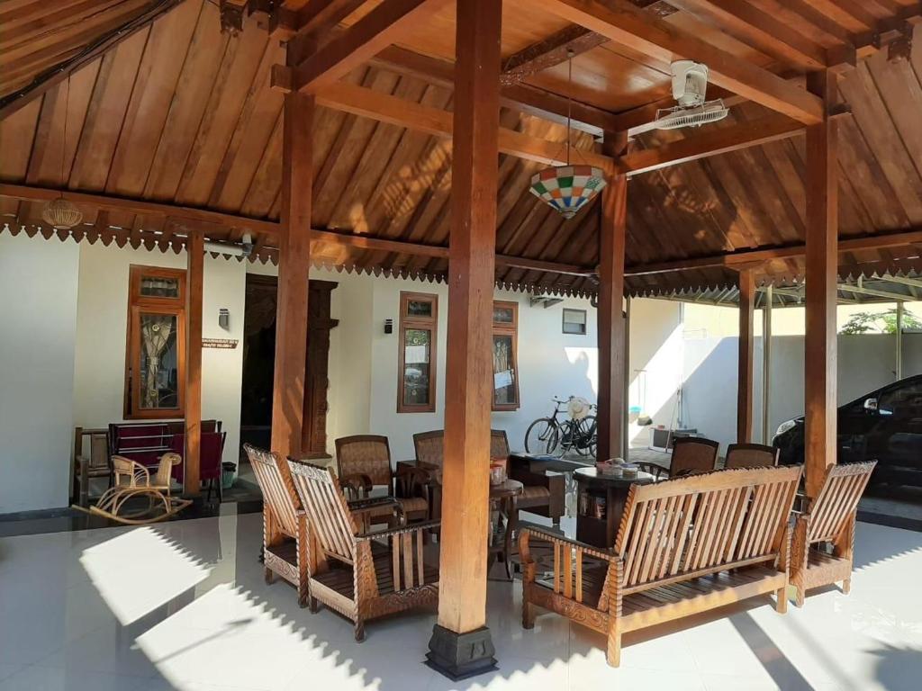 a large wooden pavilion with chairs and a table at Joglo Rahayu Homestay in Timuran