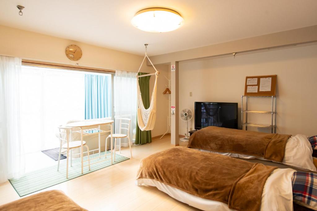 Destiny Inn Sakaiminato في ساكايميناتو: غرفة نوم بسريرين وطاولة ونافذة