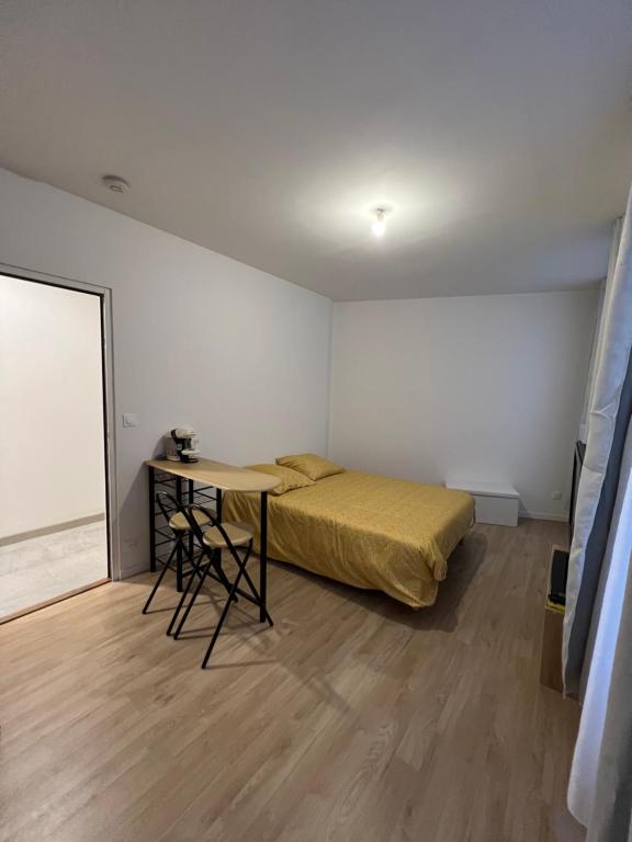 um pequeno quarto com uma cama e uma mesa em Studio meaux hyper centre em Meaux