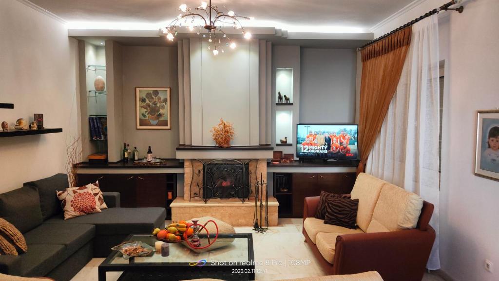 - un salon avec un canapé et une cheminée dans l'établissement Christina's House, à Chrysoupolis