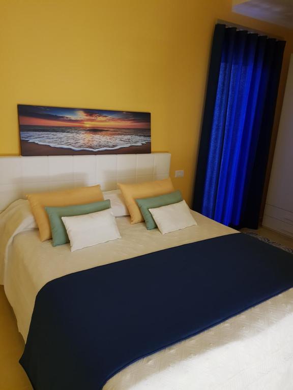 a bedroom with a large bed with blue curtains at BLU SEA SORRENTO in Sorrento