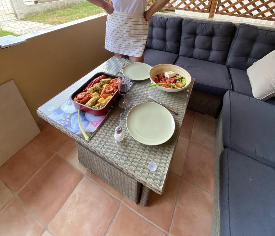 a table with plates and a tray of food on a couch at Aristotelis Apartment in Nikiti