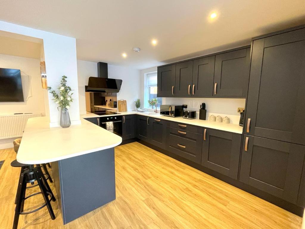 a kitchen with black cabinets and a white counter top at Ivory House in Gorleston-on-Sea