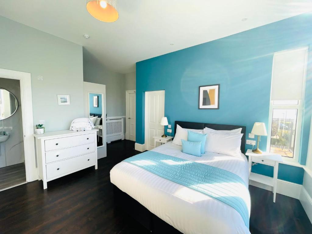a bedroom with blue walls and a large bed at Coral House in Gorleston-on-Sea