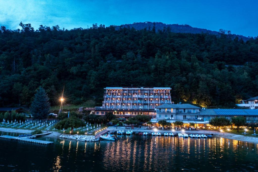 Parc Hotel Du Lac في ليفيكو تيرمي: فندق على شاطئ بحيرة في الليل