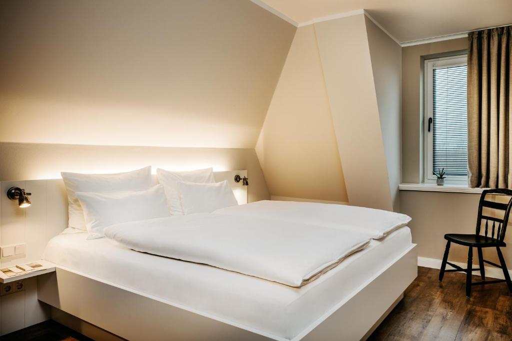 a large white bed in a room with a window at Seaside 43 in Sankt Peter-Ording