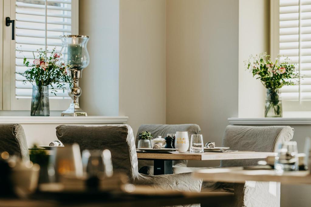 a dining room with tables and chairs and flowers at Seaside 43 in Sankt Peter-Ording