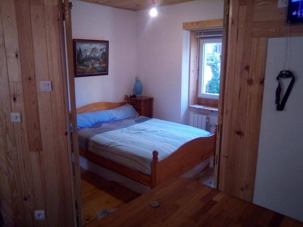 Petit village authentique في Mauléon-Barousse: غرفة نوم صغيرة بها سرير ونافذة