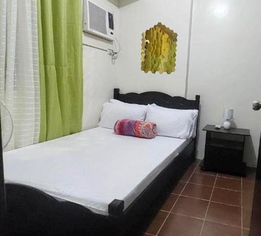 un lit avec un ours en peluche assis au-dessus dans l'établissement Rochester Condo, à Manille
