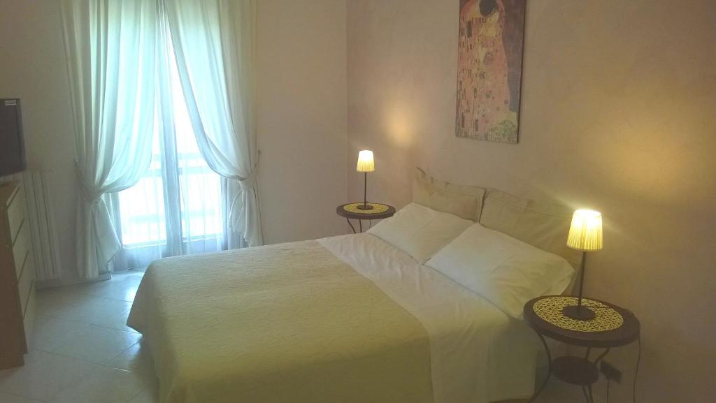 a bedroom with a white bed and two lamps on tables at Lingotto in Turin