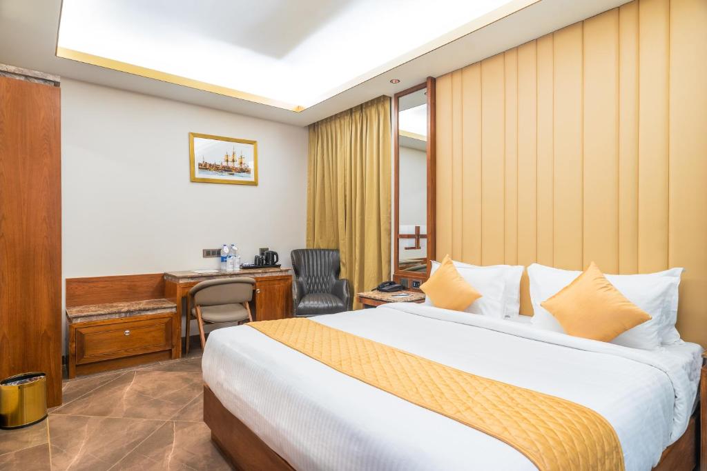 een hotelkamer met een bed en een bureau bij Marine Inn Hotel in Cochin
