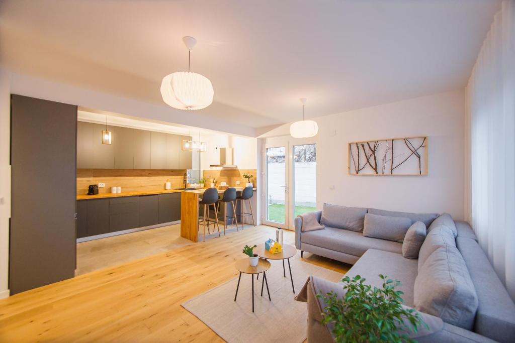 uma sala de estar com um sofá e uma cozinha em Urban Garden by Waterview em Oradea