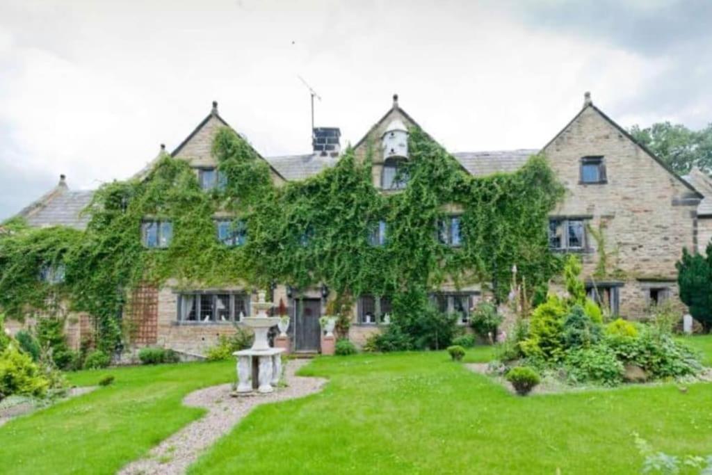 an ivy covered house with a garden in front of it at Hagg Hill Hall in Wingerworth