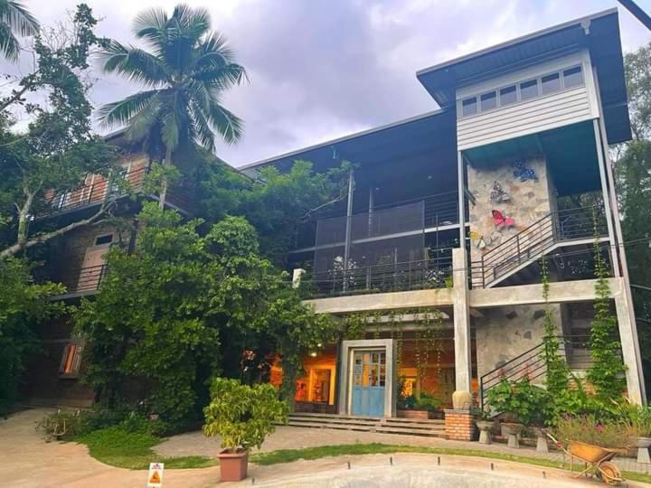 een groot blauw gebouw met een palmboom ervoor bij Ceylon Kingsmen Garden Hotel - Katunayake in Negombo