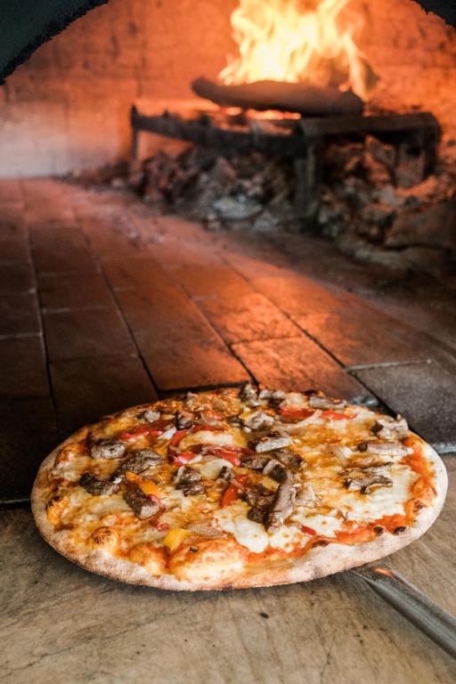 a pizza is sitting in front of an oven at Flamm in Golturkbuku