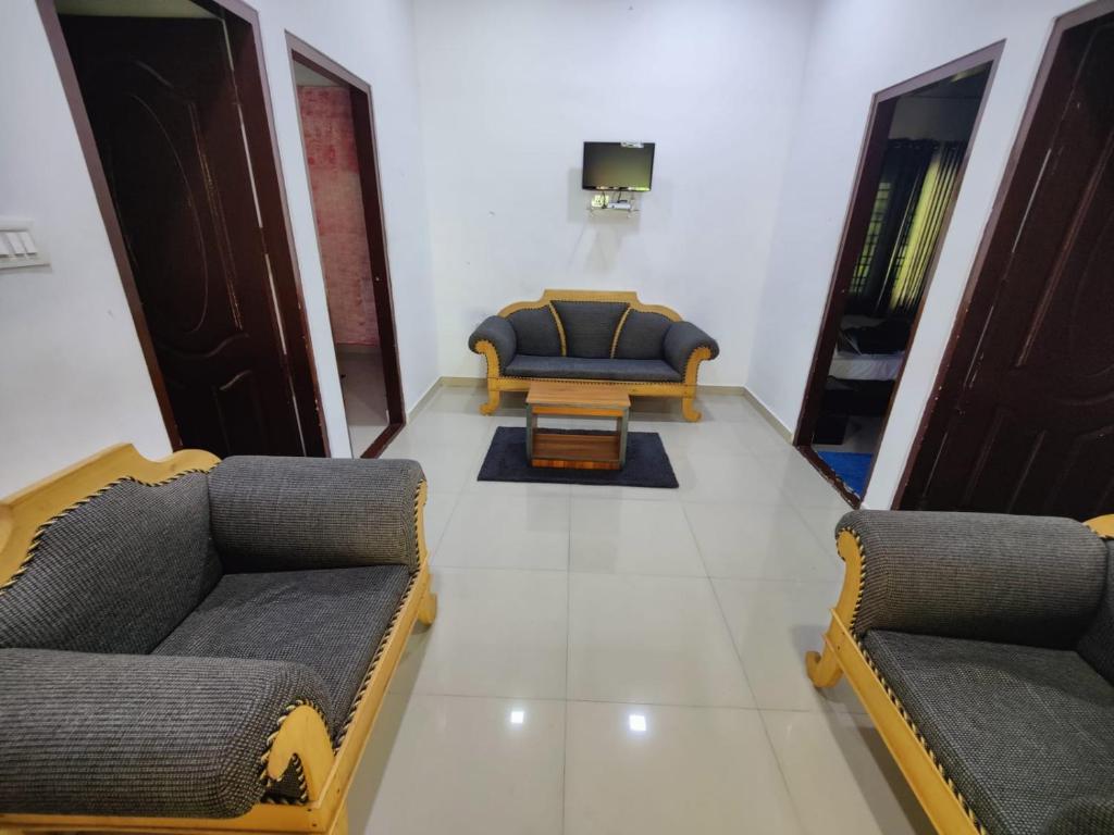 a living room with two chairs and a couch at Mazhavil homestay in Anachal