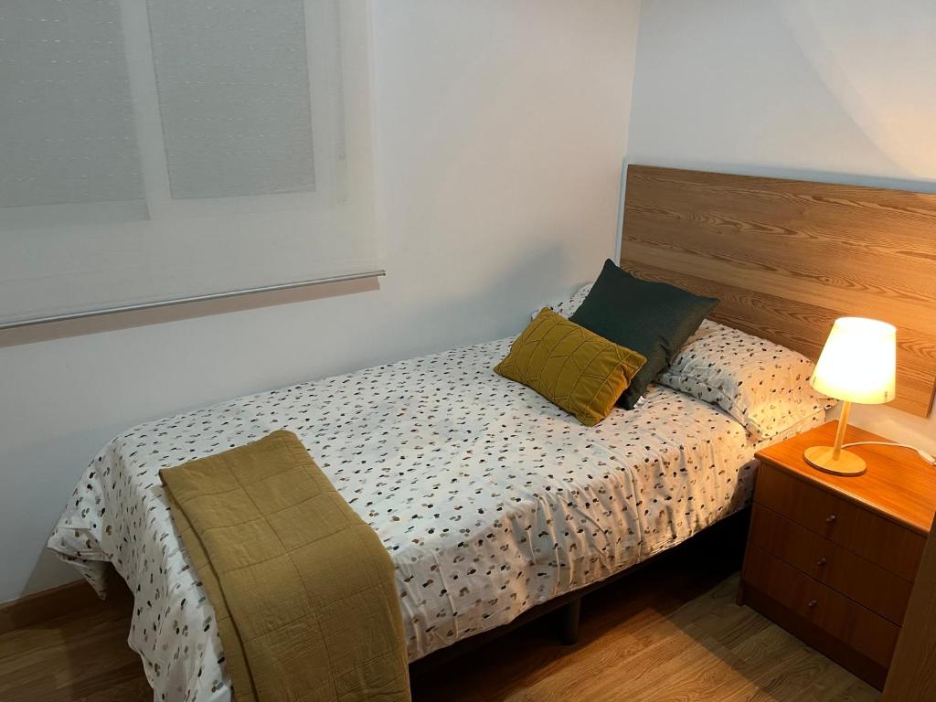 a bedroom with a bed and a nightstand with a lamp at Triana CACTUS in Melilla