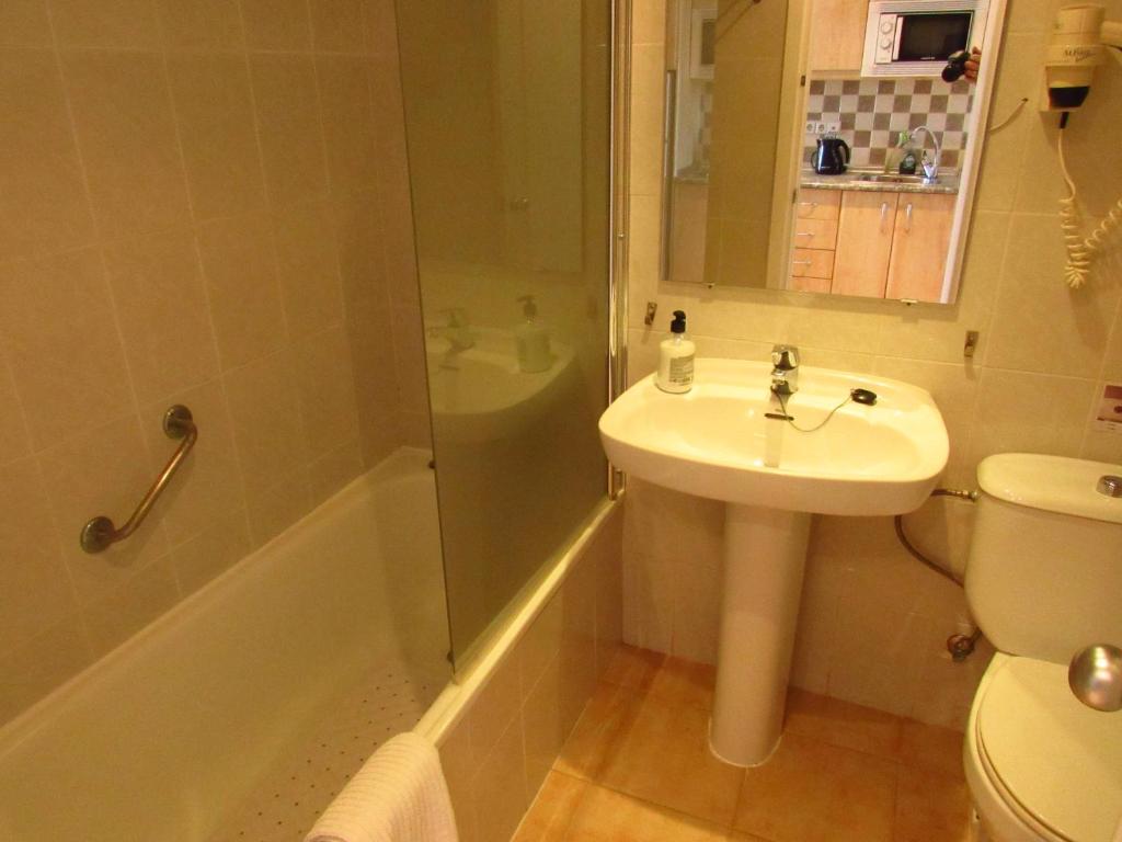 La salle de bains est pourvue d'un lavabo, d'une douche et de toilettes. dans l'établissement Benalbeach Seaview Studio, à Benalmádena