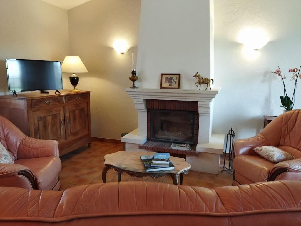 sala de estar con 2 sofás y chimenea en Maison de campagne au cœur d'un élevage de poneys connemara en Le Landreau