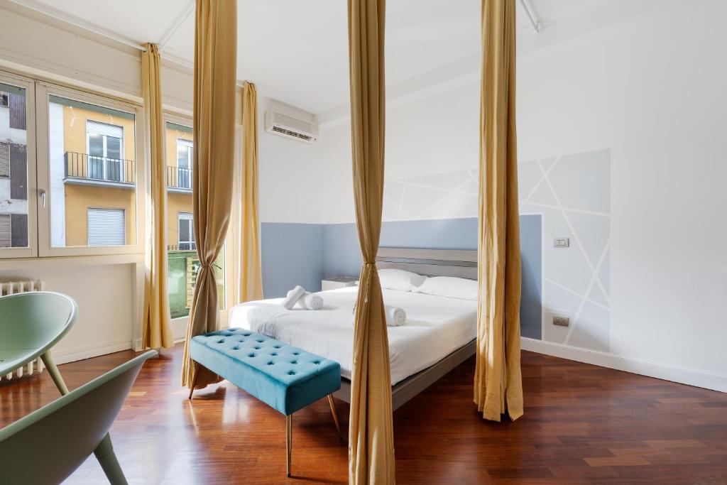 een slaapkamer met een bed en een blauwe bank bij Sempione Modern Flat in Milaan