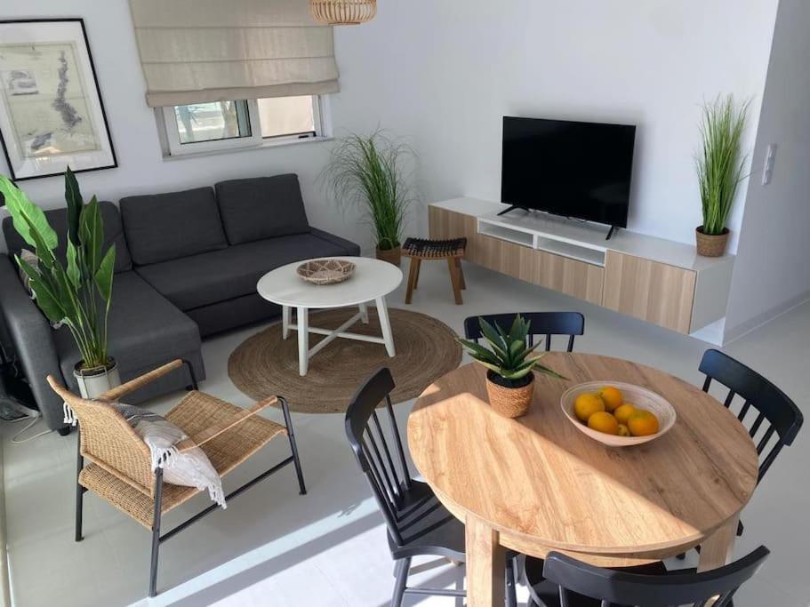 un soggiorno con tavolo e divano di The Palm Apartment Karpathos a Karpathos