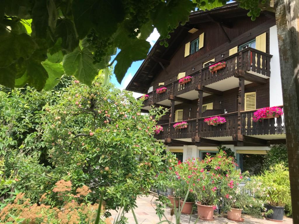 a building with a bunch of flowers in front of it at Pension Chalet Andy in Schenna