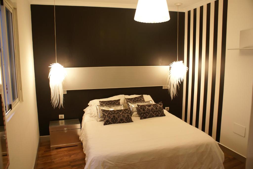 Precioso Apartamento - Casco Antiguo de Talavera في تالافيرا دي لا رينا: غرفة نوم بها سرير وعليها مصباحين