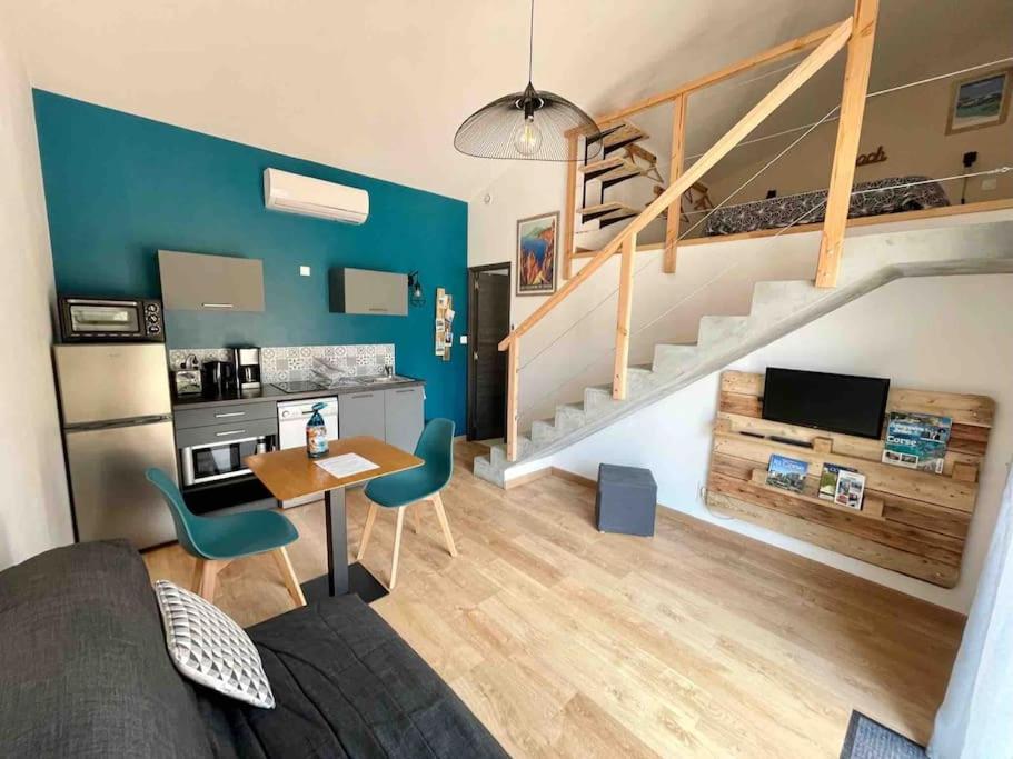 salon ze schodami, stołem i krzesłami w obiekcie Charmant duplex avec terrasse w mieście Figari