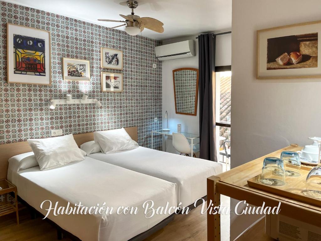 a bedroom with a bed and a table and a window at Beatriz Charming Hostal in Torremolinos