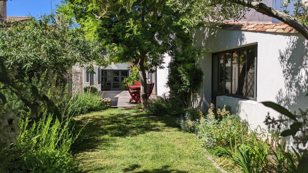 uma casa branca com um quintal com relva em Villa de charme avec Jardin dans Saint Martin Intramuros em Saint-Martin-de-Ré